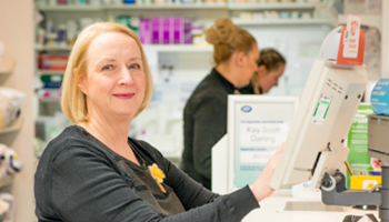 Woman behind counter in pharmacy setting image
